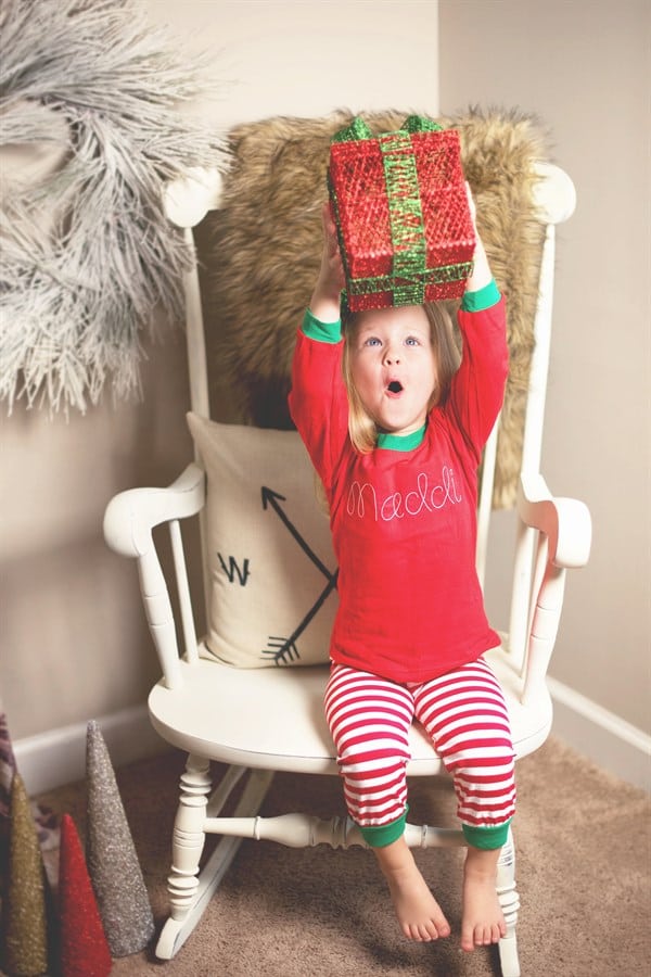 girl holding christmas gift overhead