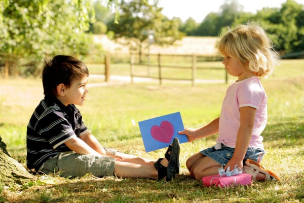 girl giving boy a valentines card