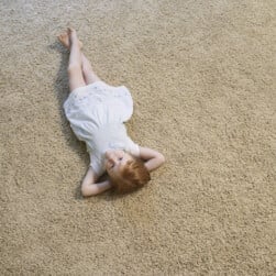 Girl Laying on Carpet Indoors