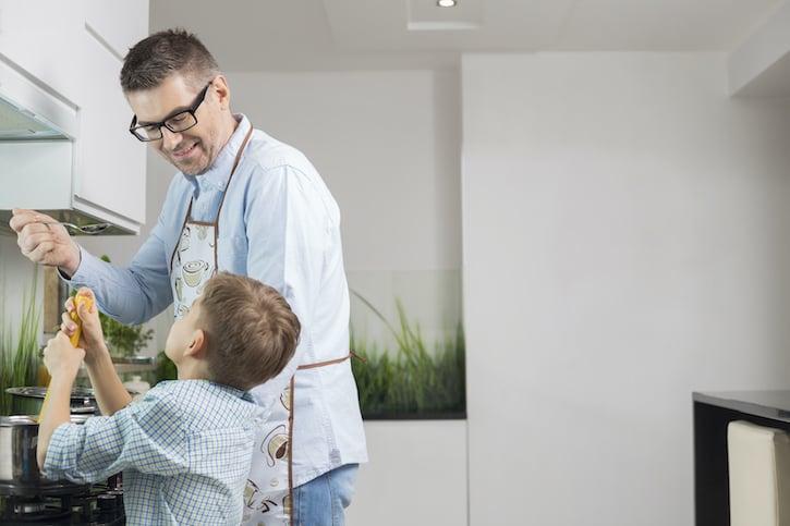 white man with glasses cooking with son