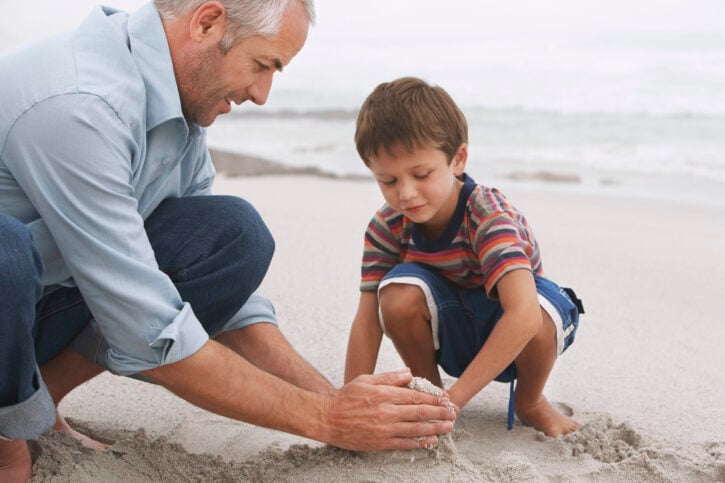 father and son playing on beach